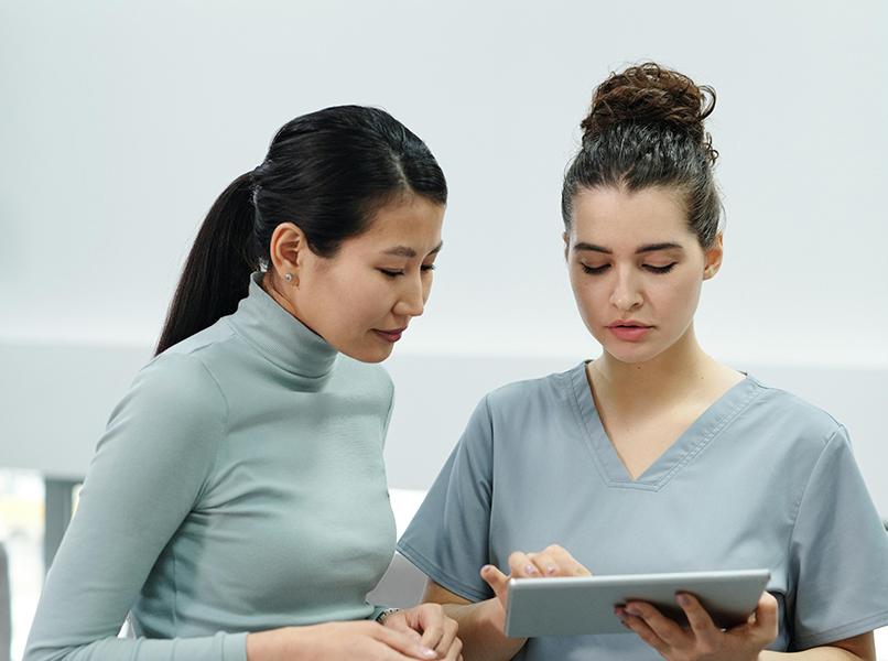 Two individuals looking at a tablet.