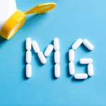 Magneisum pills arranged in the letters MG next to a bottle.