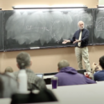 Doctor lecturing at blackboard in classtoom