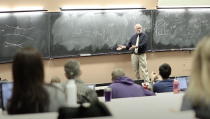 Doctor lecturing at blackboard in classtoom