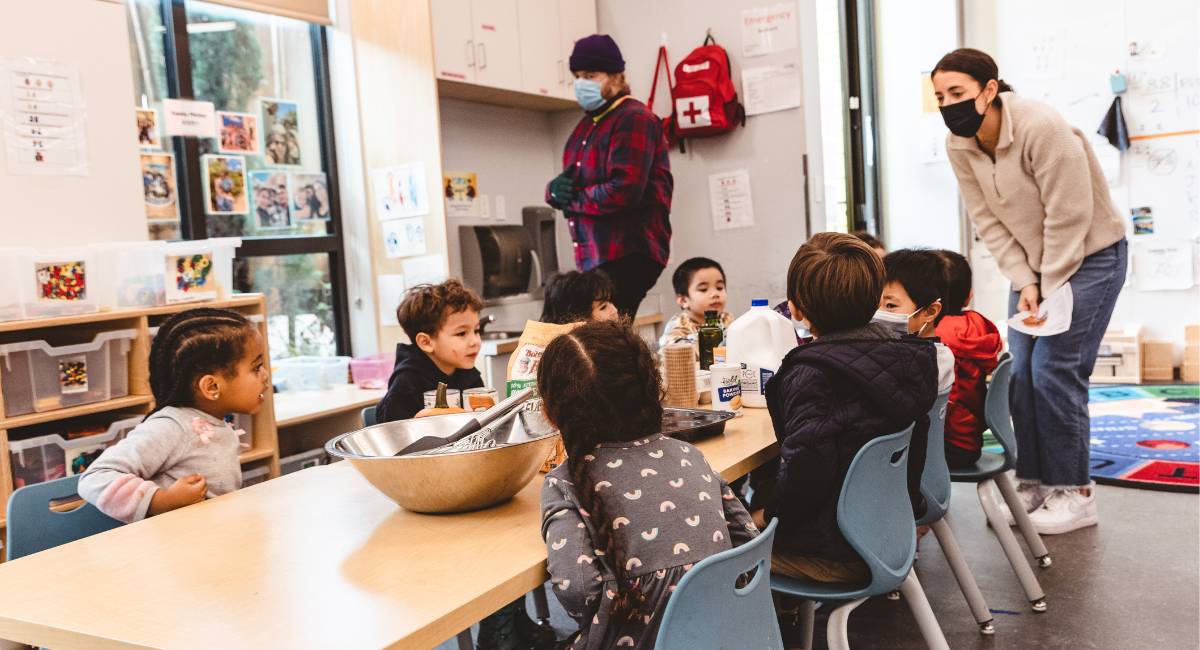 Children sitting at a table learning about food.