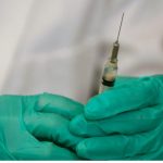 Medical provider holding a ayringe.