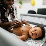 Baby on a table being screened by a pediatrician
