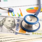 Stethoscope on a pile of paper money.